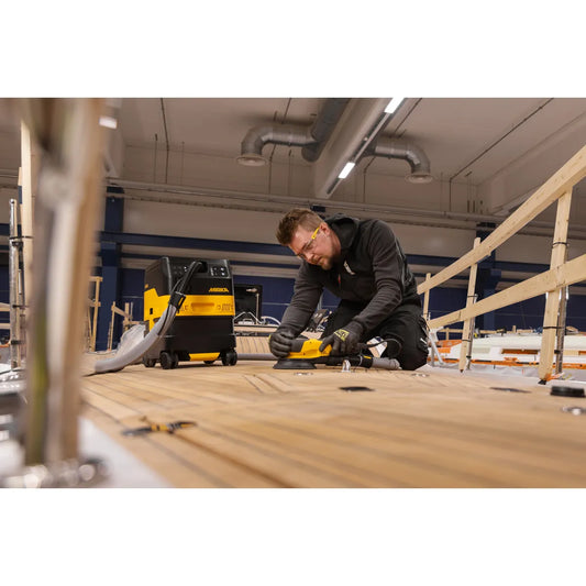 Mirka Staubsauger DEXOS 1217 M AFC im Einsatz beim Schleifen eines Bootsdecks, optimale Staubabsaugung für präzises Arbeiten in der Holzverarbeitung und Werft.