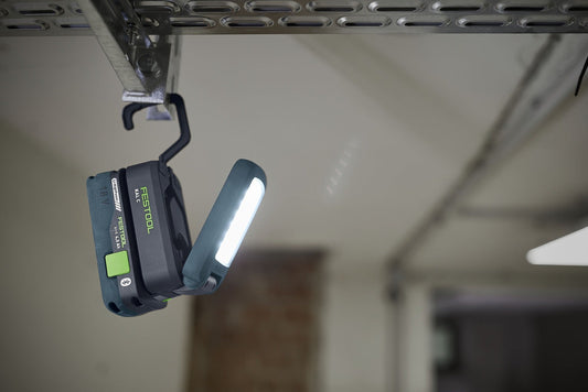 Festool SYSLITE KAL C Akku-Arbeitsleuchte mit leuchtender LED hängend an Werkstattschiene montiert
