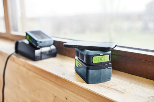 Festool Handy Ladestation PHC 18 mit grünen USB-Tasten lädt Smartphone drahtlos auf Holzwerkbank.