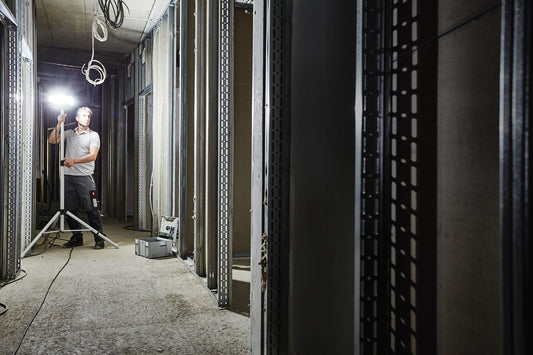 Festool SYSLITE DUO LED-Baustrahler auf Stativ bei Raumausleuchtung einer Baustelle mit 8000 Lumen Leuchtkraft
