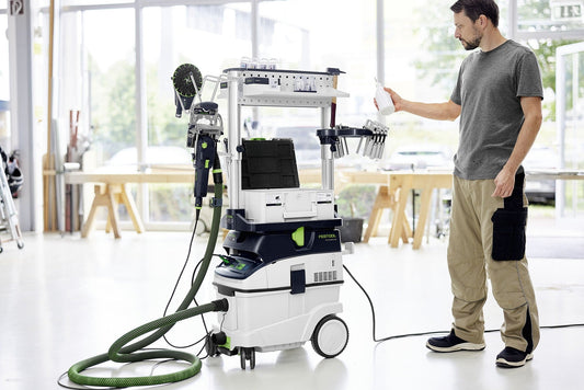 Festool Absaugmobil CLEANTEC CTL 36 EI AC mit Saugschlauch und Werkzeughalter in Werkstatt, Mann bedient Gerät.