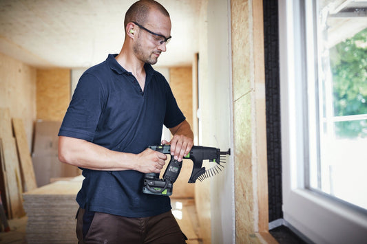 Festool DURADRIVE DWC 18-2500 Akku-Bauschrauber mit Magazinvorsatz bei Trockenbauanwendung an Wand.
