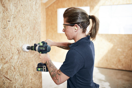 Festool Akku-Schlagbohrschrauber QUADRIVE TPC 18/4 beim Bohren in Holz, Anwendungsbeispiel mit Schutzbrille und Akku.
