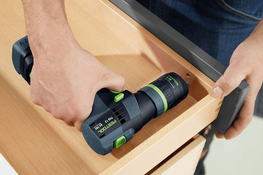Festool TXS 12 Akku-Bohrschrauber mit grünem Griffring in T-Form auf Holzoberfläche, Anwendungsansicht