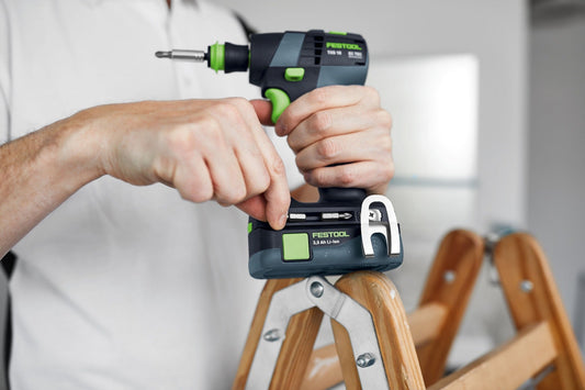 Festool TXS 18 Akku-Bohrschrauber mit 3,0 Ah Li-Ionen Akku in Hand, Anwendungsdemonstration auf Holzleiter