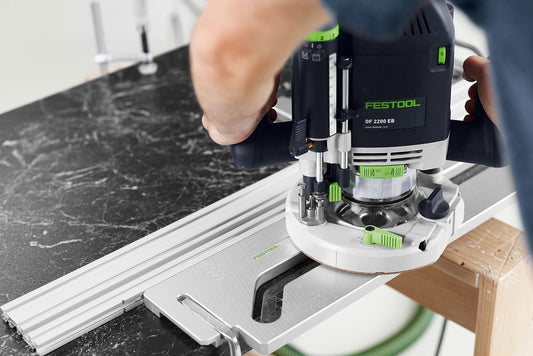 Festool OF 2200 EB Oberfräse beim Fräsen von Nut in schwarzer Arbeitsplatte mit Schablone