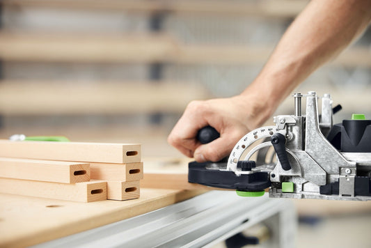 Festool DOMINO DFC 500 E-Basic Akku-Dübelfräse beim Fräsen von Dübellochlängsmustern in Holz mit Winkeleinstellung