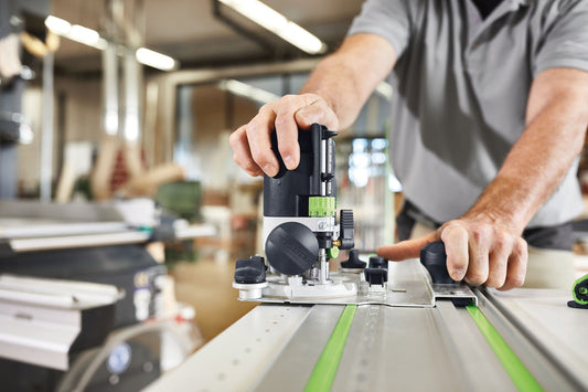 Festool Oberfräse OF 1010 REBQ-Set in Anwendung auf Werkstück mit LED-Beleuchtung und Führungssäulen
