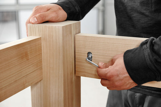 Festool DOMINO Verbinder werden in Holzeckverbindung mit Spannclement eingesetzt, Handwerker montiert Dübel.