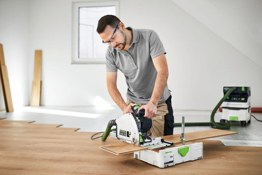 Festool Tauchsäge TS 60 KEBQ-Plus-FS bei präzisem Tauchschnitt in Holzplatte, Handwerker mit Schutzbrille