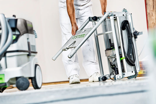 Festool Tischzugsäge PRECISIO CS 50 EBG mit Zuggriff in Anwendung beim Schneiden, Arbeitstisch und Sauganlage sichtbar