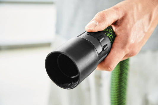 Festool Drehausgleich Antistatik-Schlauchmuffe in der Hand, schwarze Kunststoffausführung mit grünem Antistatik-Schlauch