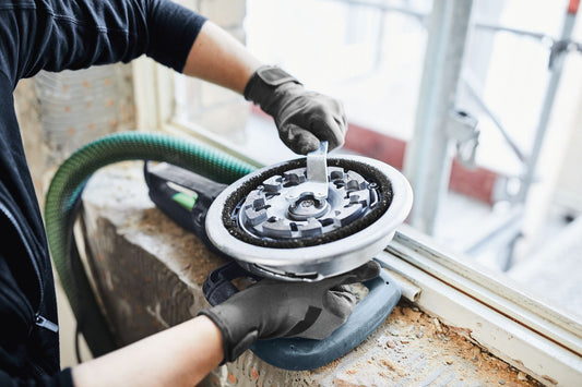 Festool Diamantscheibe mit Diamantsegmenten beim Scheibenwechsel an Renovierungsfräse, Handschuhe getragen.