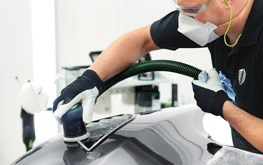 Festool IAS-Schlauch mit Absaugschlauch bei Anwendung an Druckluftschleifermaschine mit Absauganlage verbunden