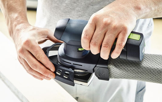 Festool DTSC 400 Akku-Deltaschleifer in Anwendung, Hände halten ergonomisches Gerät mit Bluetoothakkupack