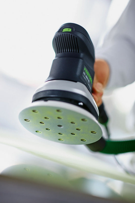 Festool ETS 150/3 EQ-Plus Exzenterschleifer mit grünem Schleifteller bei Anwendung auf Holzoberfläche
