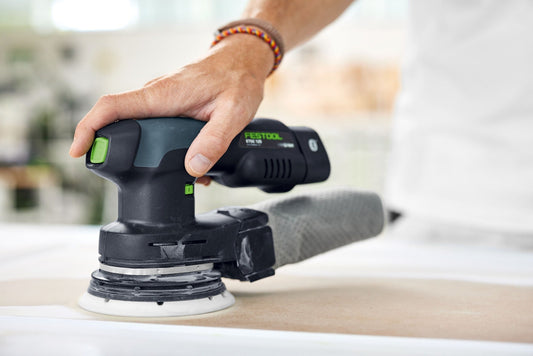 Festool Elektroschleiffer mit Schleifscheibe Granat in Anwendung auf Holzoberfläche beim Schleifen