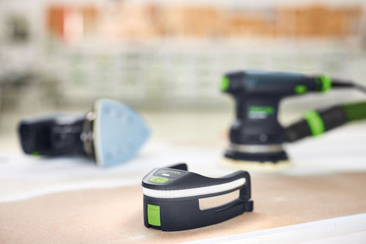 Festool Lichtmodul LM-DTS mit LED-Beleuchtung auf Holzoberfläche, im Hintergrund Kompaktschleifer